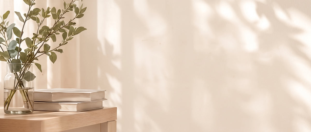 Rami di eucalipto e libri su un tavolino in legno chiaro